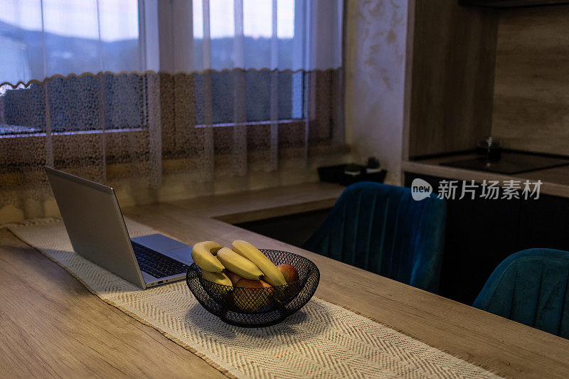 Laptop on kitchen dining table at late night.